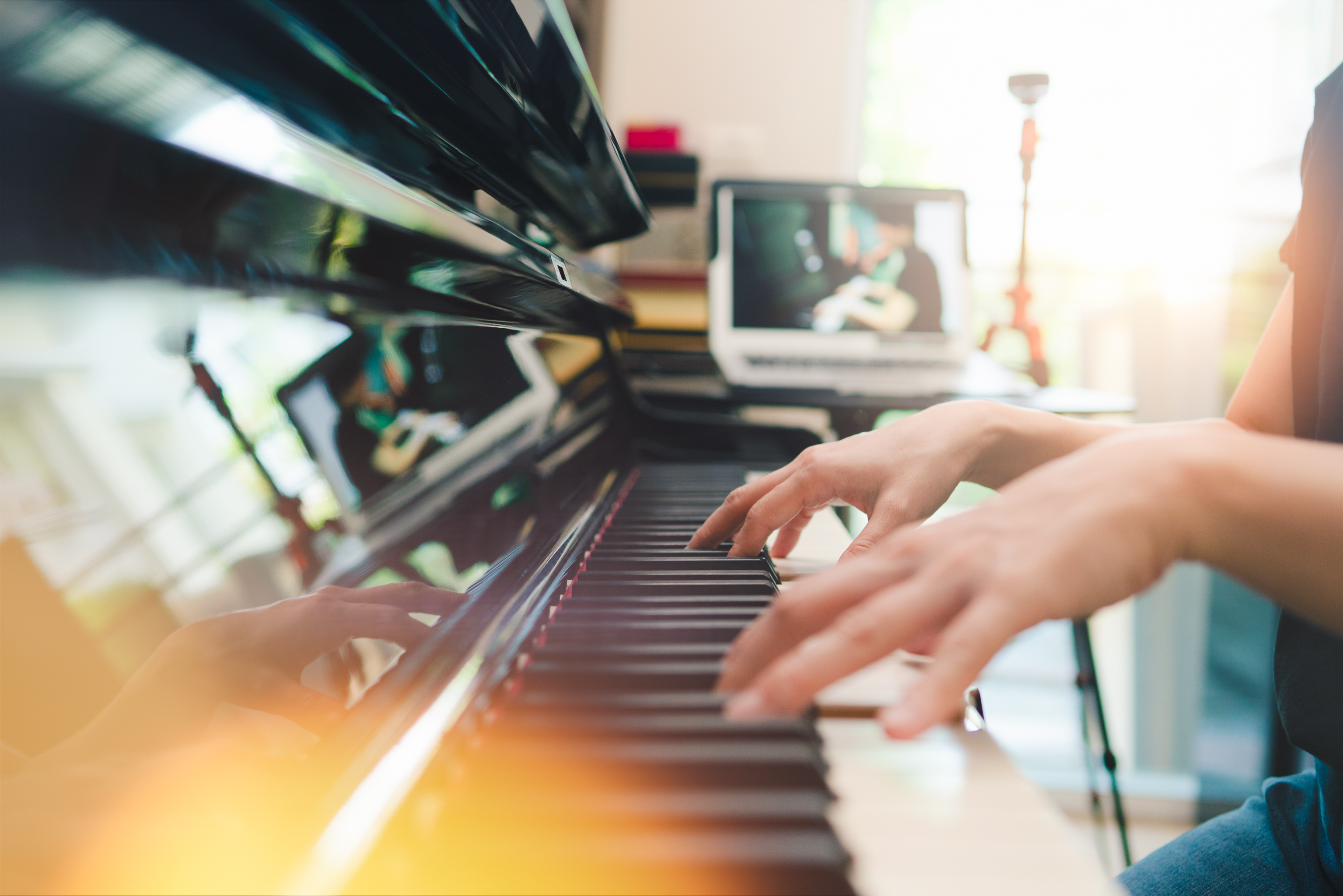 Piano online example, there is a piano with a computer and the user is playing and following the class.